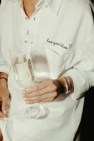 Bride wearing embroidered oversized button-down during getting-ready moment
