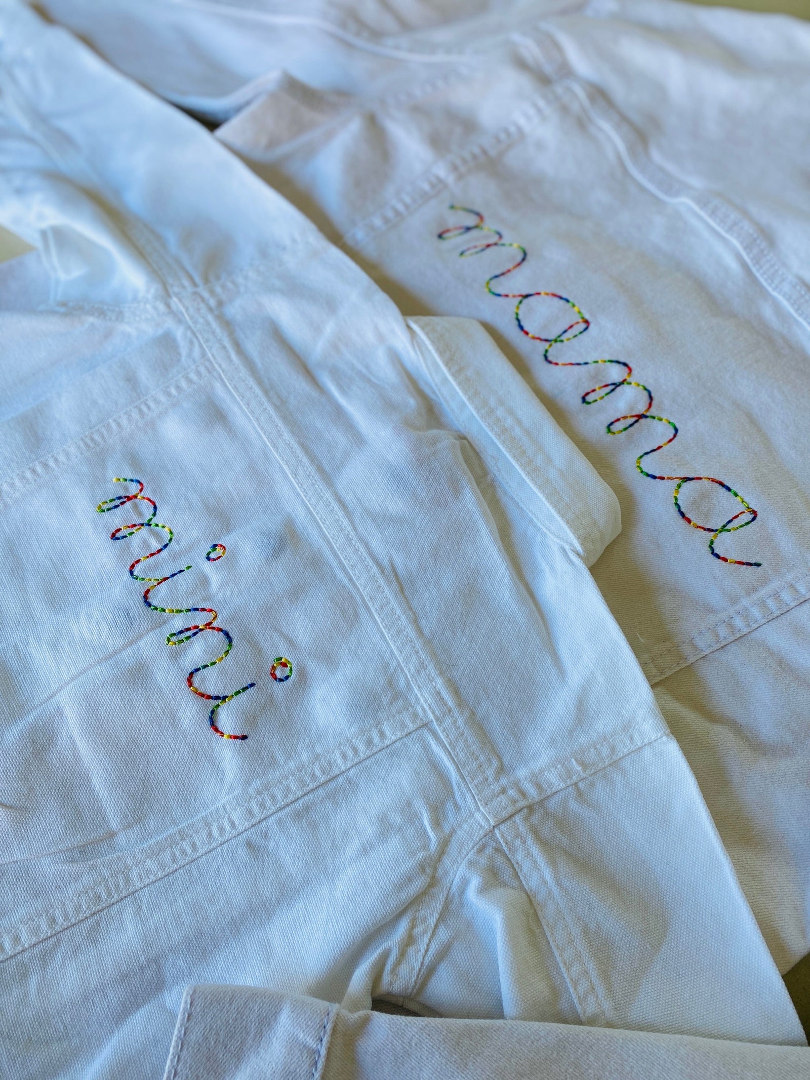 White cotton denim jacket with embroidered mini text